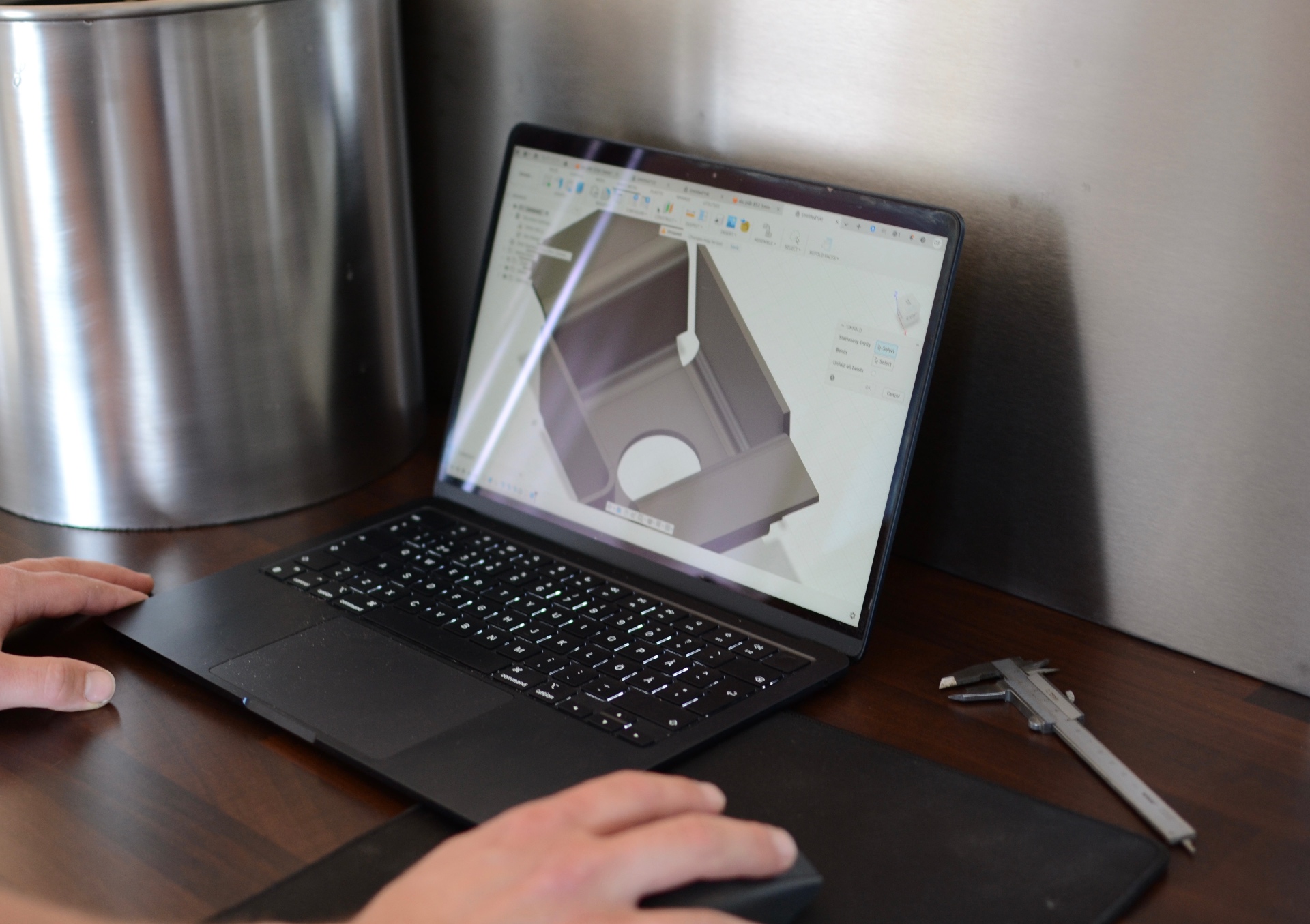 CAD-konstruktion i Fusion 360 på laptop bredvid rostfri kruka och skjutmått